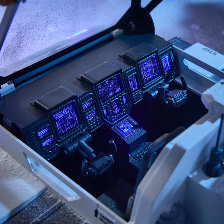 The Snow C.A.T. cockpit with the canopy raised, showing a bank of separately tooled instrument screens lit in blue